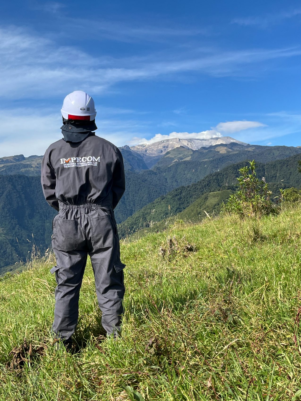 Colaborador de IMPECOM frente al Nevado del Ruiz en un sitio de cumbre